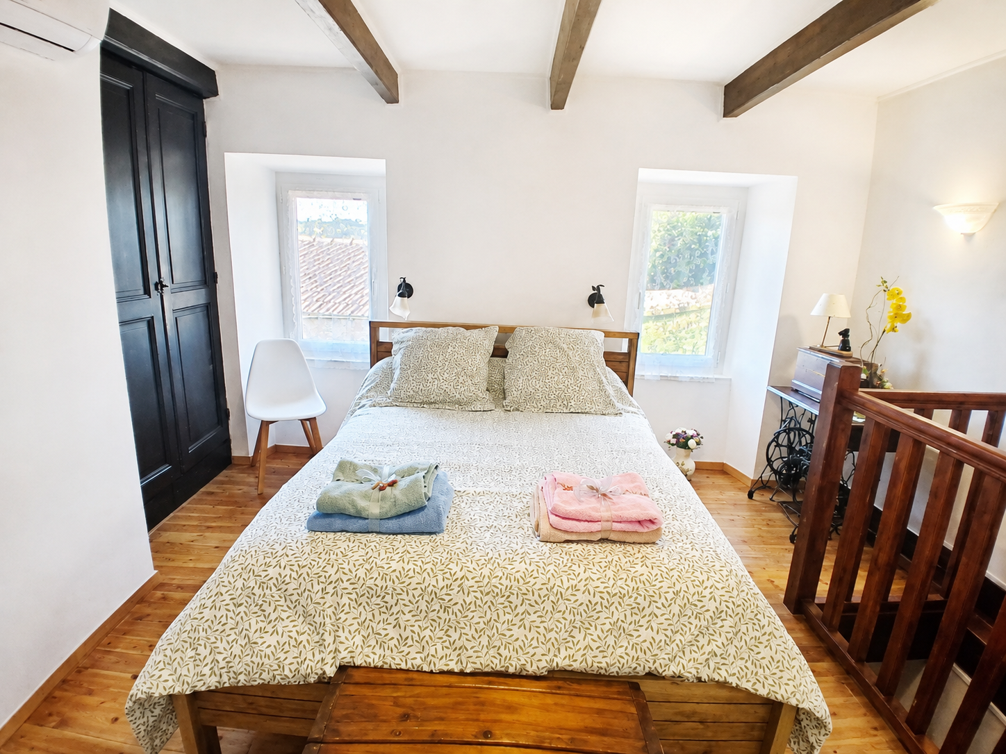 Chambre avec lit double et linge de toilette plié