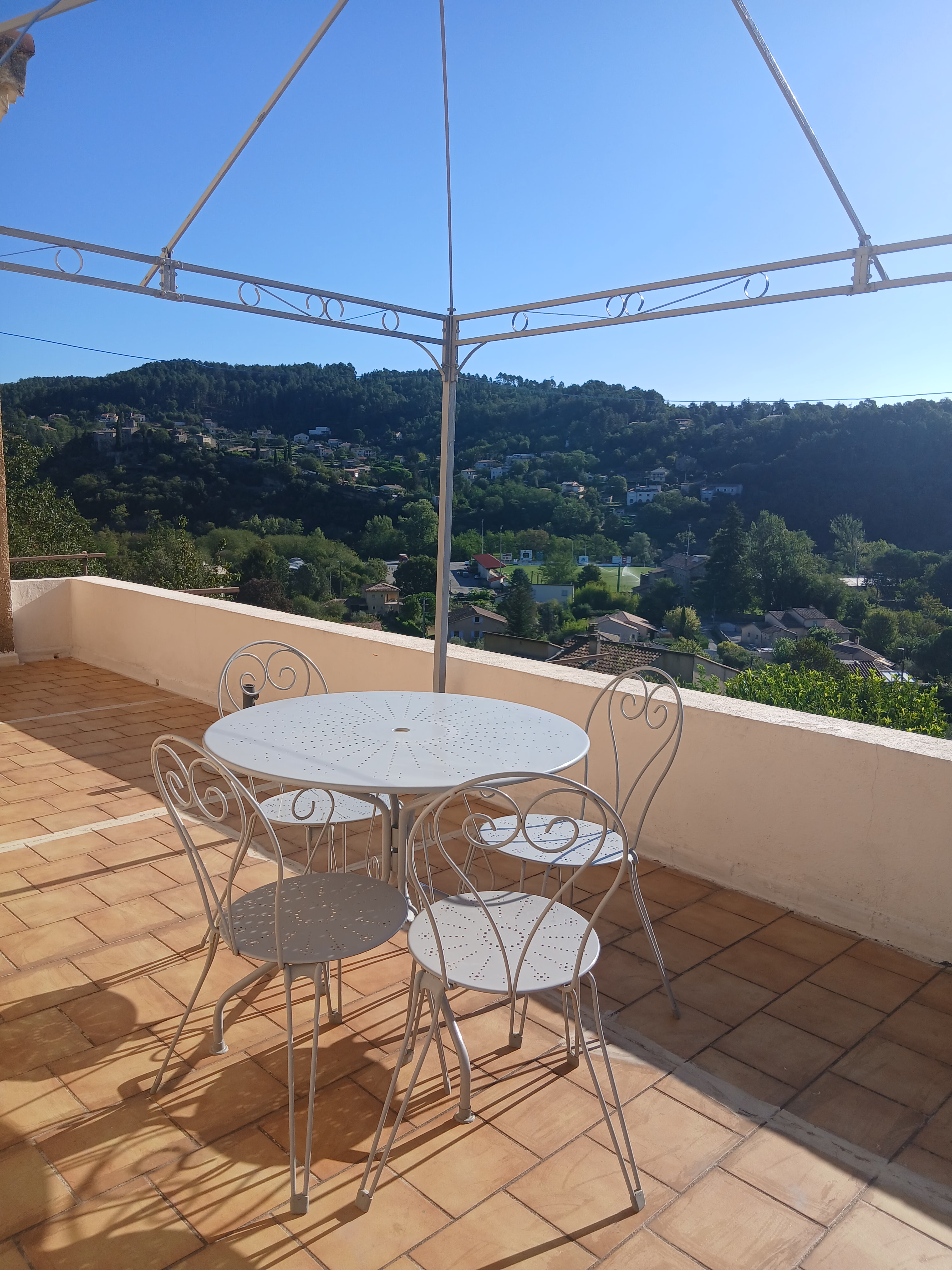 Terrasse panoramique avec table et chaises, vue sur Aubenas et les collines