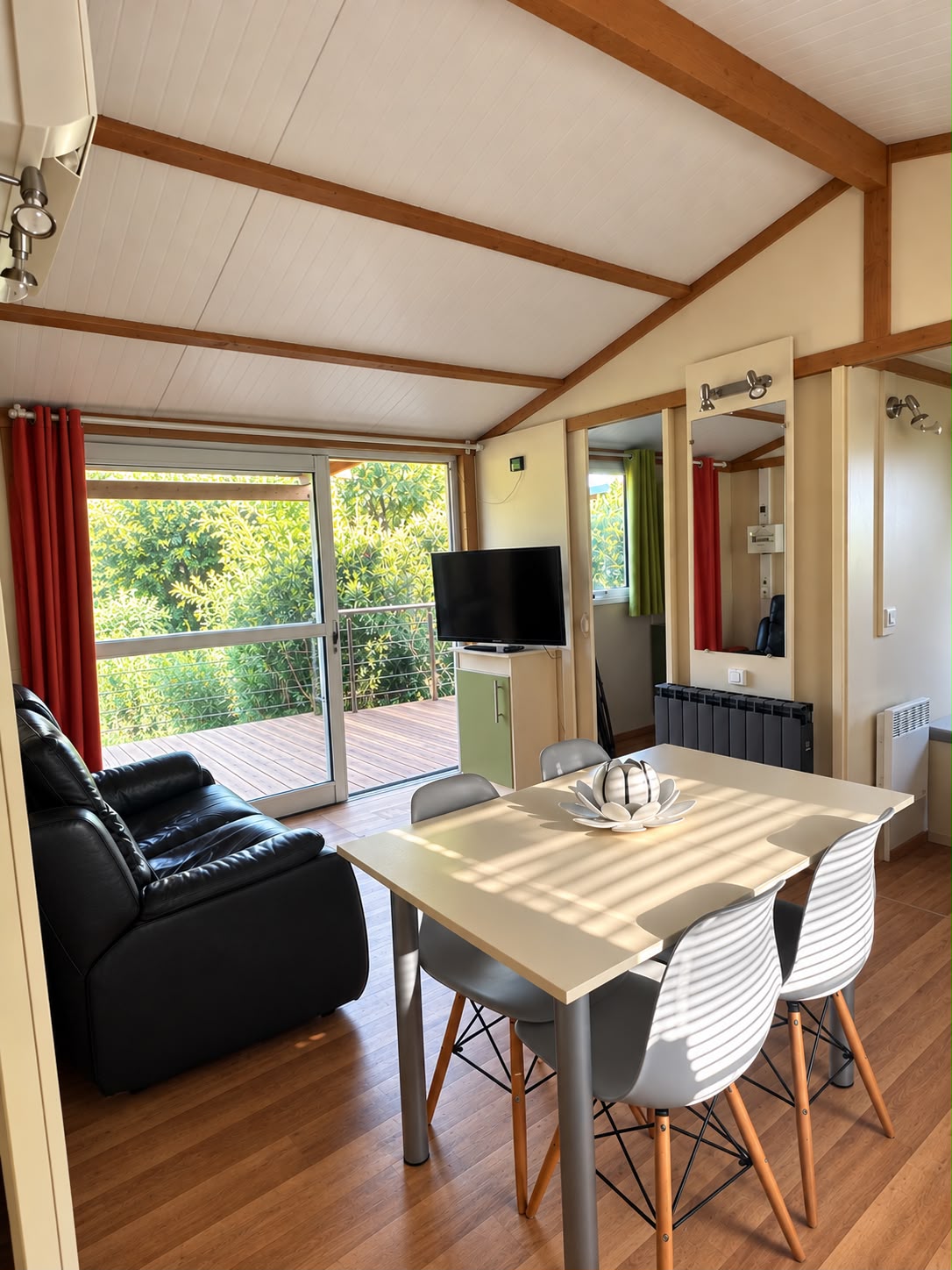 Séjour lumineux avec canapé, table à manger et accès à la terrasse