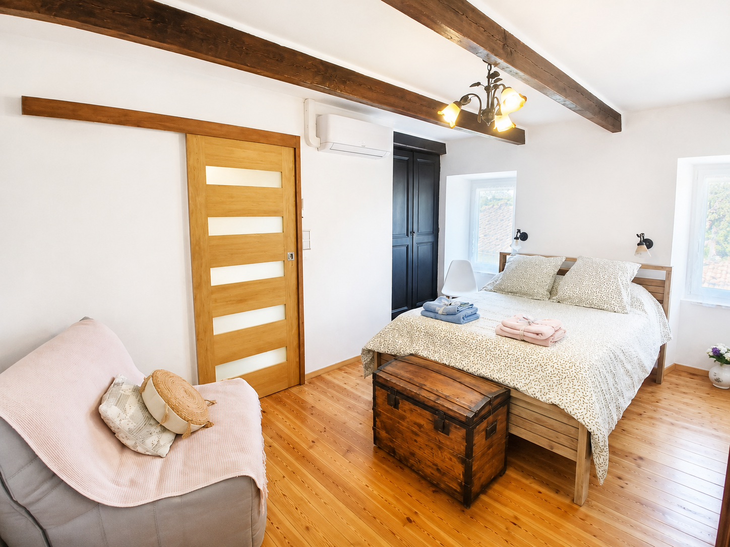 Chambre lumineuse avec lit double et salle de bain en arrière-plan